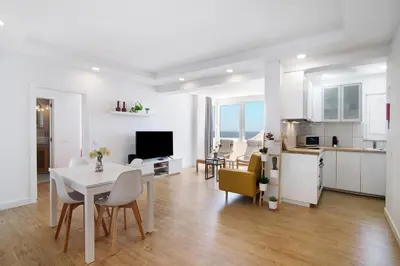 a kitchen and a living room with a table and chairs at Moderno e renovado T2 in Quarteira