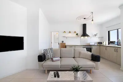 a living room with a couch and a kitchen at Lindo T2 com vista mar in Quarteira