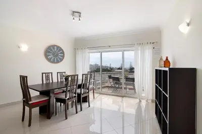 a dining room with a table and chairs and a clock at Vilamoura Marina in Vilamoura