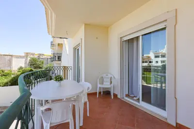 a balcony with a white table and chairs and a window at Apart ALGARVE - Piscina - BY BEDZY in Albufeira