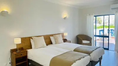 a bedroom with a large bed and a balcony at Jardim da Oura by Check-in Portugal in Albufeira