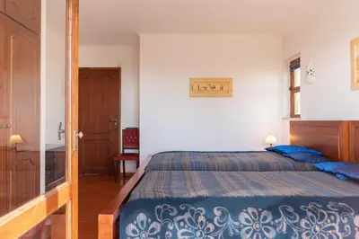a bedroom with a large bed with blue pillows at Villa Andrea by Gabi Miguel in Albufeira