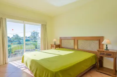 a bedroom with a green bed and a large window at Villa Agua by Gabi Miguel in Albufeira