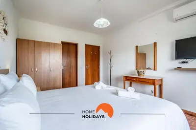 a bedroom with a large white bed with a tv at #158 T3 Panorama C by Home Holidays in Albufeira