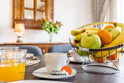 a bowl of fruit on a table with a cup of orange juice at #158 T3 Panorama C by Home Holidays in Albufeira