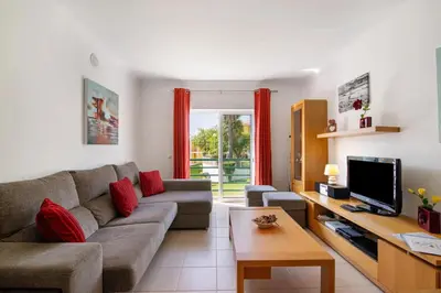 a living room with a couch and a tv at T2 Encosta São José by Gabi Miguel in Guia