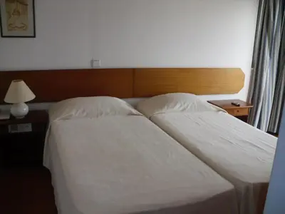 a bedroom with two beds and a lamp on a table at Aparthotel Dom Pedro Portobelo in Vilamoura