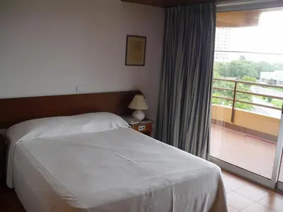 a bedroom with a bed and a window with a balcony at Aparthotel Dom Pedro Portobelo in Vilamoura