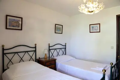 two beds in a bedroom with a chandelier at Sunset Pôr do sol in Galé