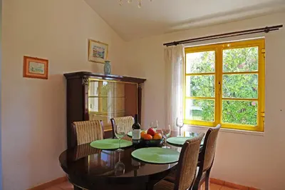 a dining room with a table and chairs and a window at Sunset Pôr do sol in Galé