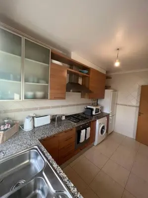 a kitchen with a sink and a refrigerator at Apartamento Falésia c/ Piscina in Albufeira