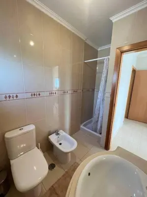 a bathroom with a toilet and a tub and a sink at Apartamento Falésia c/ Piscina in Albufeira