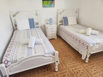 two beds sitting next to each other in a bedroom at Albufeira Traditional Apartments IN VILLA in Albufeira