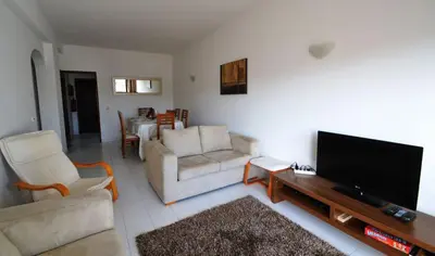 a living room with couches and a flat screen tv at T3 Olhos de Água in Albufeira
