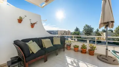 a balcony with a couch and some potted plants at Design Top Floor With Balcony & Pool in Vilamoura