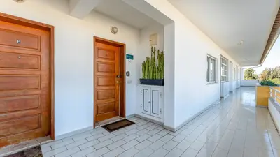 a hallway with a wooden door and white walls at Design Top Floor With Balcony & Pool in Vilamoura
