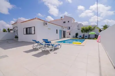 a villa with a swimming pool and two chairs at Avo Isabel by Innkeeper in Guia