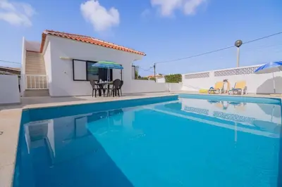 a villa with a swimming pool and a house at Avo Vitoria by Innkeeper in Guia