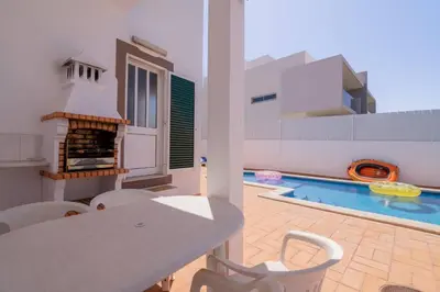 a living room with a table and a swimming pool at Galé Igor by Innkeeper in Guia