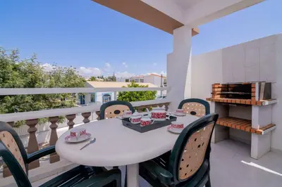 a white table and chairs on a balcony at Galé Igor by Innkeeper in Guia