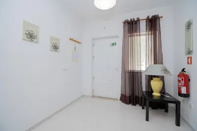 a room with a lamp on a table and a door at Galé Magda by Innkeeper in Guia