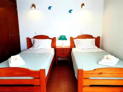 two twin beds in a room with a night stand and a bedskirts at Corte Real Apartment AE - Sea & Old Town View in Albufeira