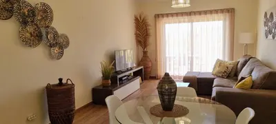 a living room with a glass table and vases on the wall at Superbe Paradis dans les Jardins de la Marina in Albufeira