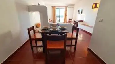 a dining room with a table and chairs in a room at Bright apartment with sea view in Albufeira - 67 m² + pool in Albufeira