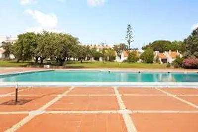 an empty tennis court with a tennis court at Bright apartment with sea view in Albufeira - 67 m² + pool in Albufeira