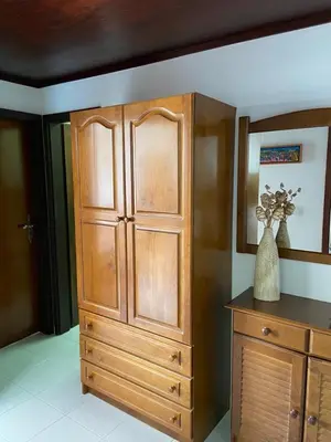 a large wooden cabinet with a vase on top of it at Quarteira-Mar in Quarteira