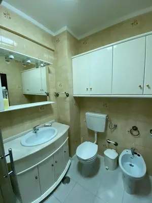 a bathroom with a sink and a toilet and a mirror at Quarteira-Mar in Quarteira