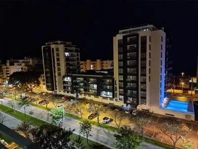 a view of two tall buildings at night at Quarteira-Mar in Quarteira