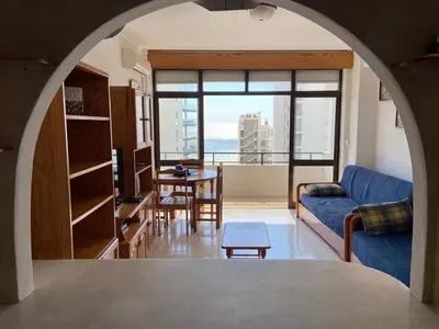 a living room with a blue couch and a table at Quarteira-Mar in Quarteira
