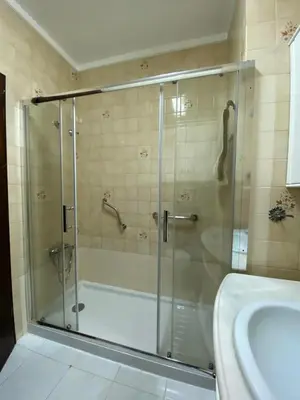 a bathroom with a shower and a tub and a sink at Quarteira-Mar in Quarteira