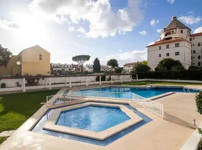 a large swimming pool with a building in the background at Vilamoura Marina Apartment by Stay ici Algarve Holiday Rental in Quarteira