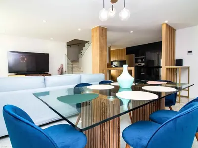a living room with blue chairs and a glass table at Sea la Vie House by Stay ici Algarve Holiday Rental in Albufeira