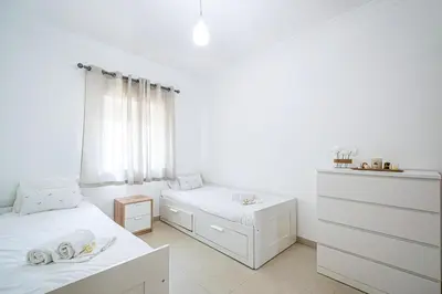 a white bedroom with two beds and a dresser at BeGuest Summer Breeze in Vale Parra in Galé