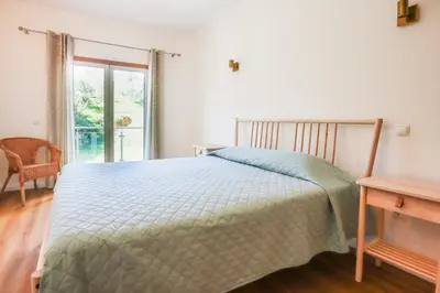 a bedroom with a bed and a table and a window at Villa ENCOSTA VISTA SALGADOS - BY BEDZY in Guia