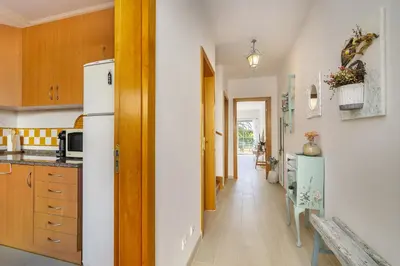 a kitchen with a refrigerator and a hallway at Rosal Beach House in Albufeira