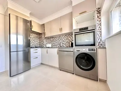 a kitchen with a washer and dryer in it at Holiday Apartment Albufeira in Albufeira