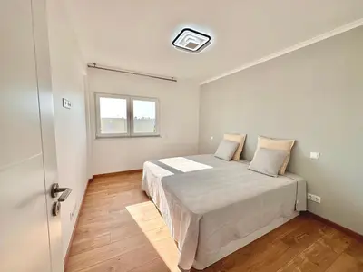 a bedroom with a bed and a window and a door at Holiday Apartment Albufeira in Albufeira