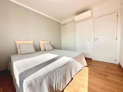 a bedroom with a large bed with white sheets at Holiday Apartment Albufeira in Albufeira