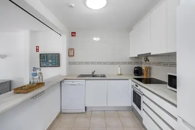 a white kitchen with white cabinets and a sink at Casa Solar in Guia