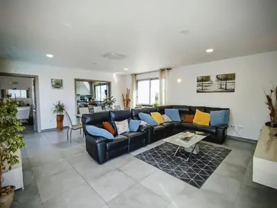 a living room with a black couch and a table at Villa Luz 37 - Jacuzzi Terrace & Swimming Pool in Albufeira