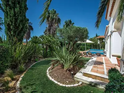 a garden with a pathway leading to a house at Exquisite Quinta Da Lago Villa Villa Majestic Heights 4 Bedrooms in Almancil
