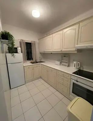 a kitchen with white cabinets and a white refrigerator at Casa Oura Sea Living in Albufeira