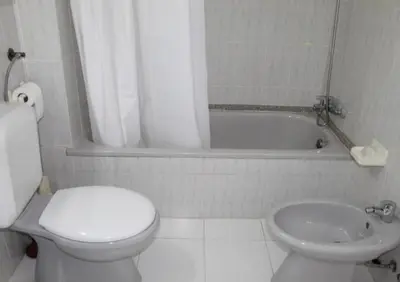 a bathroom with a toilet and a sink and a tub at Casa Oura Sea Living in Albufeira