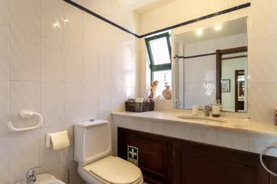 a bathroom with a toilet and a sink and a mirror at TAC - Vila Tina Vilamoura in Quarteira