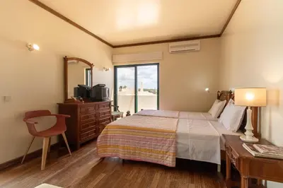 a bedroom with a bed and a dresser and a window at TAC - Vila Tina Vilamoura in Quarteira