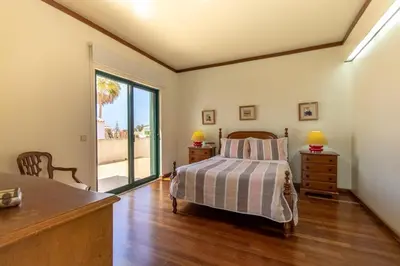 a bedroom with a bed and a sliding glass door at TAC - Vila Tina Vilamoura in Quarteira
